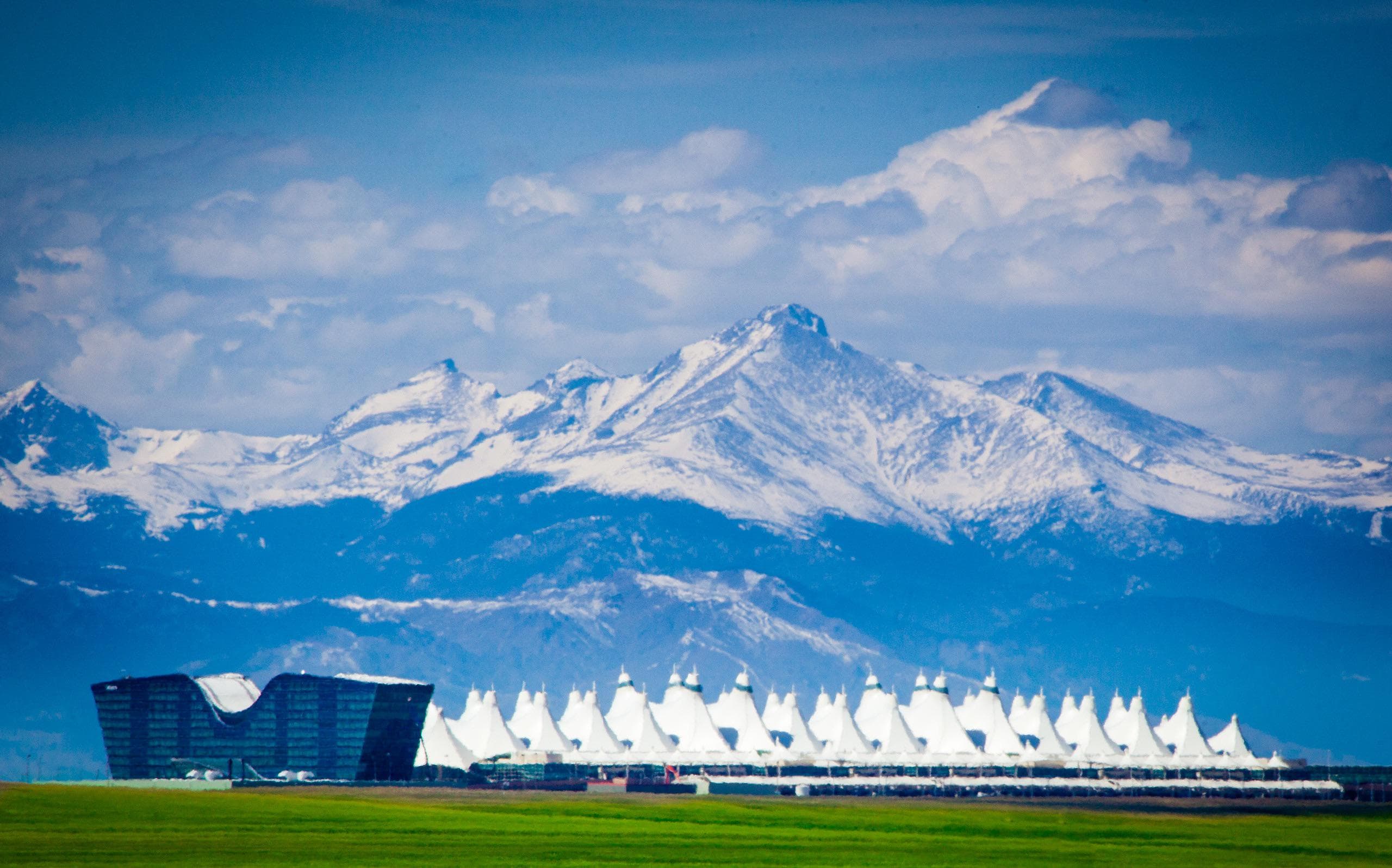 Denver International Airport iconic white tent roof with Rocky Mountains backdrop